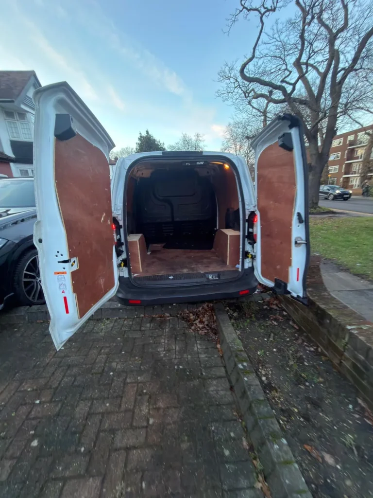 Ford Transit Courier small van with rear doors open showing the lined load space
